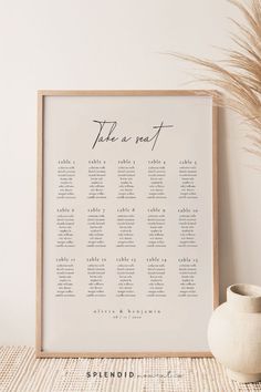 a wedding seating chart is displayed in front of a vase with pamy grass on it