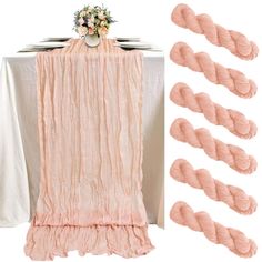 the table is covered with pink ruffled linens and there are flowers on top