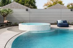 an outdoor swimming pool with lounge chairs around it