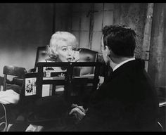 marilyn monroe talking to a man in a chair with pictures on the back of his head