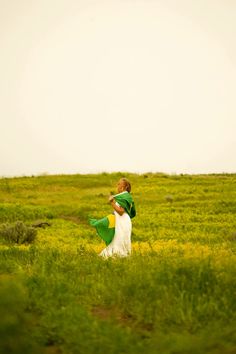 a woman walking through a lush green field