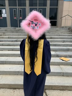 a person with long hair wearing a graduation gown and a pink hat on top of their head