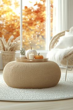 a living room filled with furniture and a large window covered in fall leaves, pumpkins and acorns