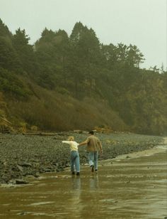 two people walking on the beach holding hands