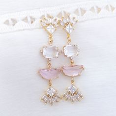 Wear this exquisite pink statement earrings to your wedding or any formal event and channel the glamorous art deco era. This art deco feature a unique arrangement of clear and light pink crystals that catch and reflect light from every angle, creating a mesmerizing play of shimmer and sparkle.The secure push back closure ensures that you can dance and mingle with confidence, knowing that your earrings will remain in place.✨Suggested occasion for wear: your wedding, wedding guest, bridal shower, Elegant Pink Crystal Earrings, Chic Sparkling Stones Jewelry For Wedding, Pink Crystal Earrings For Pierced Ears, Formal Pink Chandelier Earrings, Chic Wedding Jewelry With Sparkling Stones, Pink Cubic Zirconia Crystal Earrings, Pink Crystal Drop Bridal Earrings, Elegant Pink Chandelier Earrings For Formal Occasions, Elegant Pink Chandelier Earrings For Formal Events