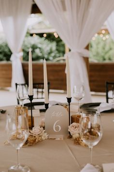 the table is set with wine glasses and candles