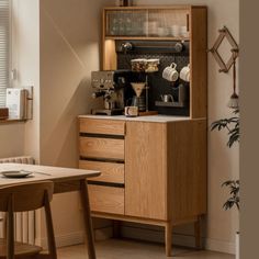 a wooden cabinet sitting in the corner of a living room next to a table and chairs