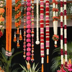 an arrangement of flowers and garlands hanging from the ceiling