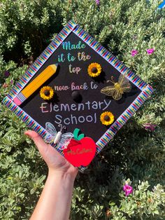 a hand holding up a graduation cap that says made it to the new back to elementary school