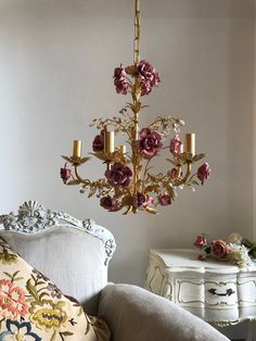 a chandelier hanging from the ceiling in a room with white walls and furniture