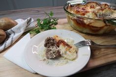 a white plate topped with food next to a casserole dish