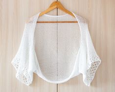 a white sweater hanging on a wooden hanger