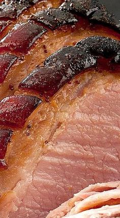 closeup of sliced ham on a plate with red wine glaze in the center