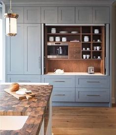 a kitchen with blue cabinets and wooden counter tops