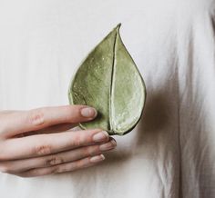 a woman holding a green leaf in her hands