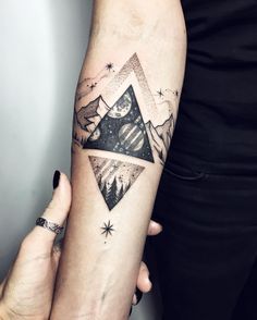 a woman's arm with a mountain and stars tattoo on the left side of her arm