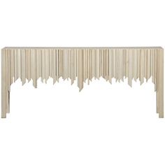 a white console table with long fringes on the top and bottom, against a white background