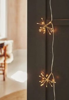 a string of lights is hanging on the side of a black cabinet in a room