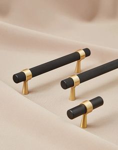 three black and gold handles on a beige cloth