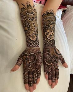 two hands with henna designs on them