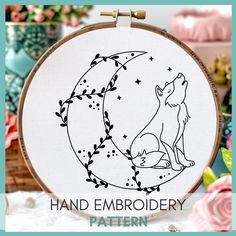 a cross stitch pattern with a wolf sitting on the moon and stars in the sky