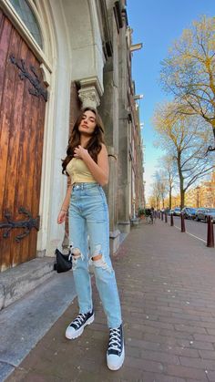 a woman standing in front of a door with her hand on her hip and looking up