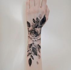 a woman's arm with a rose tattoo on it