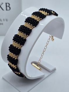 black and gold beaded bracelet on white stand