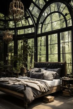 a bedroom with large windows and a bed in the middle, surrounded by greenery