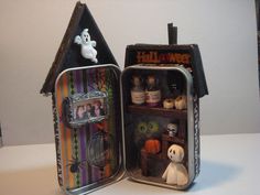 an open tin can with halloween decorations in it and a dog figurine inside