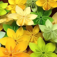 many different colored paper flowers are arranged in the shape of large, green and yellow flowers