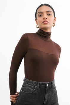 Timeless and head-turning at once, our Cara Top is a reimagined take on the classic long sleeve turtleneck top. Fully covered feels lighter than air with our premium European jersey construction, which we've made sheer at the neckline and sleeves for an unexpected hint of skin. Cara's high-stretch fabric fits just so in all the right places and she's breathable enough to layer across seasons. | Palak, in espresso, is 5'9.5" (176.5 cm) tall, wearing size XS. Natalee, in black, is 5'10" (178 cm) t Brown Long Sleeve Outfit, Brown Top Outfit, Sheer Turtleneck, Sheer Outfit, High Neck Tops, Designer Board, Classic Turtleneck, Turtleneck Sweaters, Boho Aesthetic