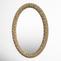 an oval mirror with braiding on the sides