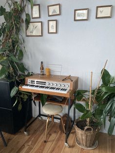 an electronic keyboard sitting on top of a wooden table next to a potted plant