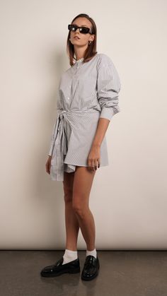 The Sierra shirt dress is effortlessly chic. It's made from crisp cotton-poplin with a loosely draped top and close-fitting mini skirt. Unbutton the collar to create a more relaxed look. Dress is designed to look like a deconstructed shirt worn back to front. Detailed with buttons along the reverse, it's cut from cotton-poplin and has a loose shape tempered by ties at the waist meant to resemble a second pair of sleeves. 100% Cotton Deconstructed Shirt, Draped Top, Holiday Party Outfit, Black Shirt Dress, Blazer Dress, Blue Jacket, Cotton Poplin, Bridesmaid Dress, New Black