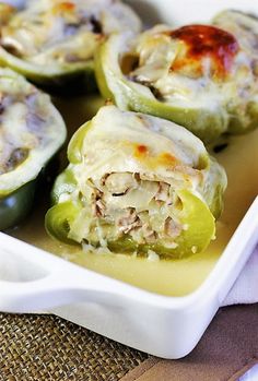 several stuffed peppers in a white dish on a table