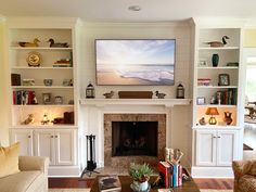 a living room filled with furniture and a flat screen tv mounted on the wall above a fire place