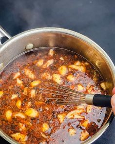 someone is stirring some food in a pot