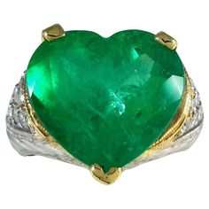 18K Two-Tone Heart-Shape Emerald Diamond Ring! Indulge in the allure of our exquisite 18K Two-Tone Heart-Shape Emerald Diamond Ring, a perfect fusion of sophistication and timeless elegance. Ring Highlights: Metal: 18K Two-Tone Gold - A harmonious blend of white and yellow gold Gemstone: Heart-Shape Emerald - The symbol of rebirth and eternal love Diamonds: Surrounding the emerald for added brilliance Design: A unique and enchanting heart-shape setting Why Choose Our Emerald Diamond Ring? Timele