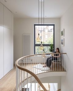 a woman sitting on top of a spiral staircase