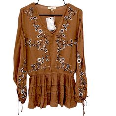 Floral Embroidery Elastic Waist Ruffled Bottom Ties At Neck Brown Embroidered Long Sleeve Blouse, Casual Embroidered Brown Blouse, Casual Brown Embroidered Blouse, Brown Floral Embroidered Long Sleeve Top, Embroidered V-neck Top For Fall, Brown Long Sleeve Top With Floral Embroidery, Fall Embroidered V-neck Top, Spring Embroidered Brown Top, Embroidered Brown Tops For Spring