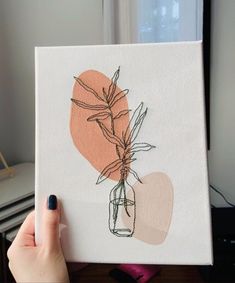 a person holding up a painting with flowers in it