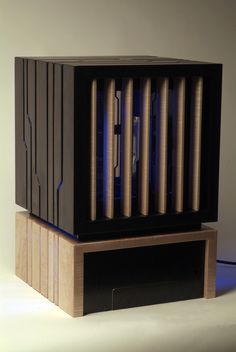 a large wooden box with blue lights in the middle on top of a table next to a white wall