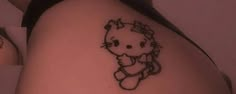 a hello kitty tattoo on the back of a woman's left shoulder and leg