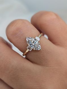 a woman's hand holding a diamond ring