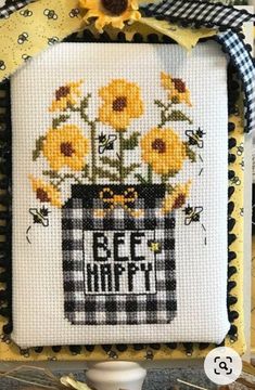 a cross stitch picture with sunflowers in a vase