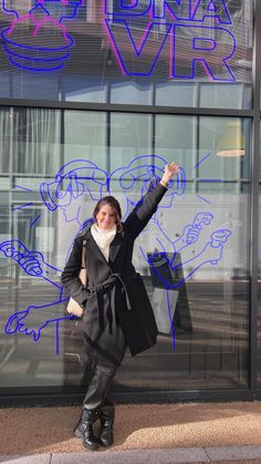 a woman standing in front of a glass building