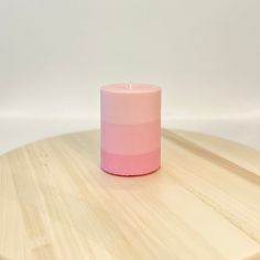 a pink candle sitting on top of a wooden table