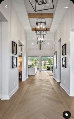 a large open floor plan with wood floors and chandelier hanging from the ceiling