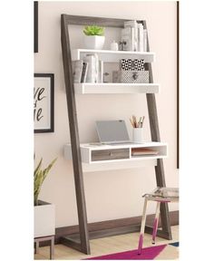 a desk with a laptop on it in front of a book shelf that is leaning up against the wall